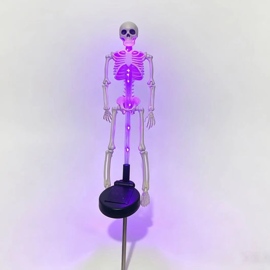 Solar Halloween tombstone stake lights glowing in a front yard